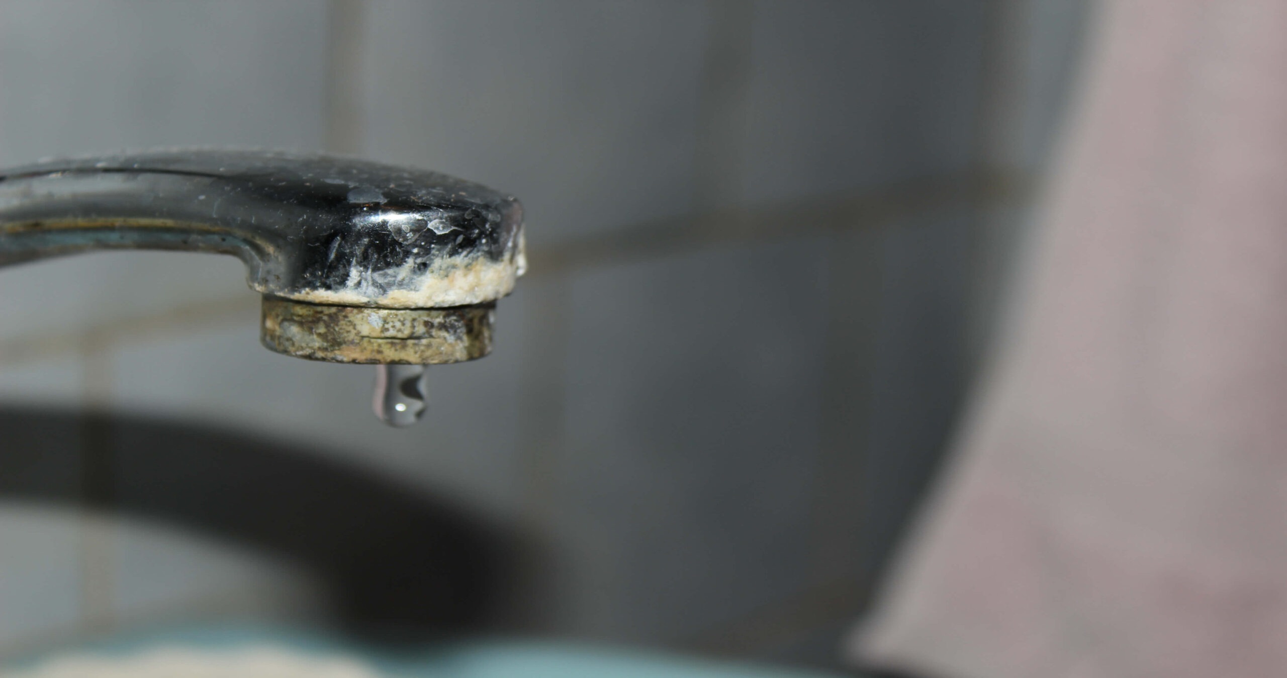 Close-up of a tap with scale buildup, demonstrating the need for anti-scale systems